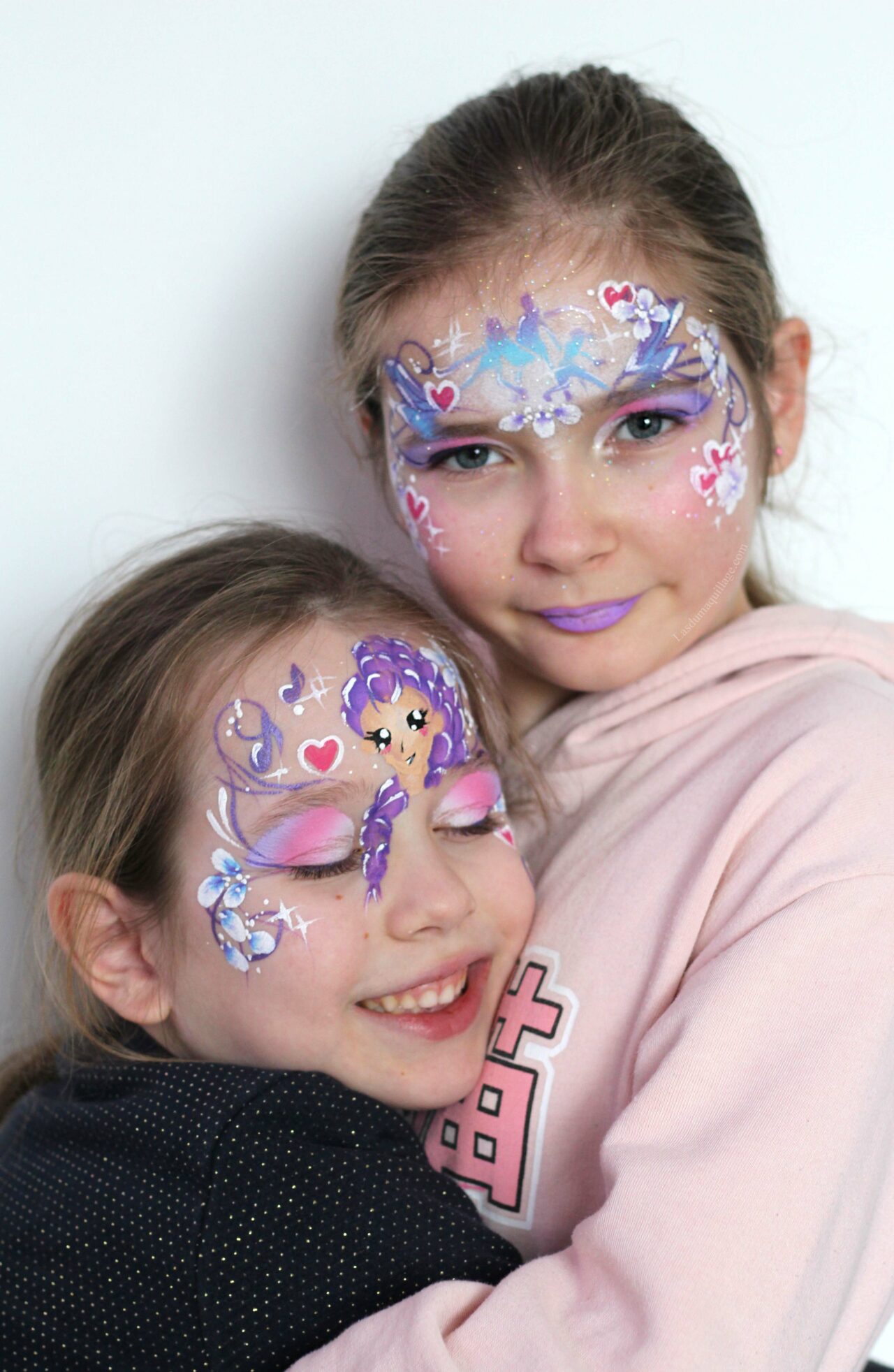 Duo d’enfants maquillés sur le thème K-Pop Demon Hunters, un face painting avec pochoir et un face painting dessiné, adaptés à différents niveaux de prestation.